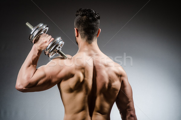 Muscular ripped bodybuilder with dumbbells Stock photo © Elnur