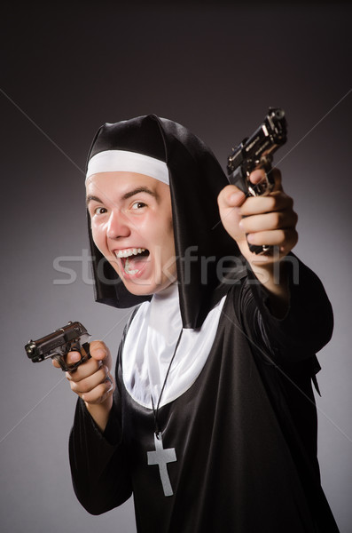 Stock photo: Man dressed as nun with handgun