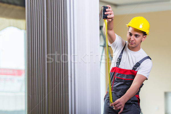 Young repairman with tape measure working on repairs Stock photo © Elnur