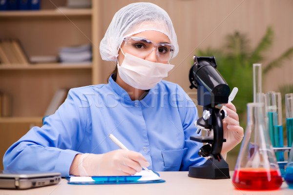Lab chemist working with microscope and tubes Stock photo © Elnur
