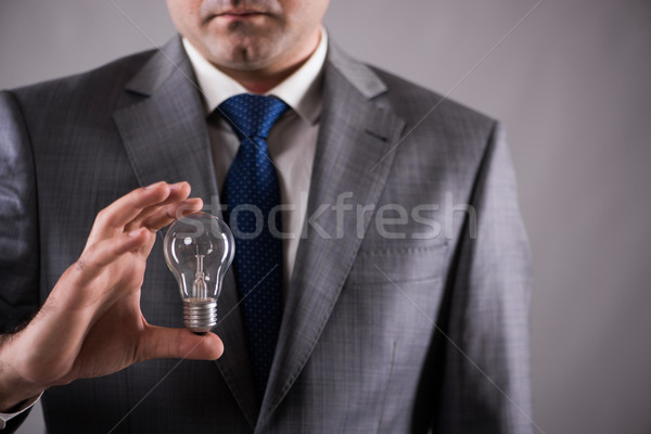 Businessman holding light bulb in creativity concept Stock photo © Elnur