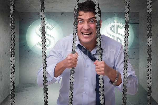 Stock photo: Man trapped in prison with dollars