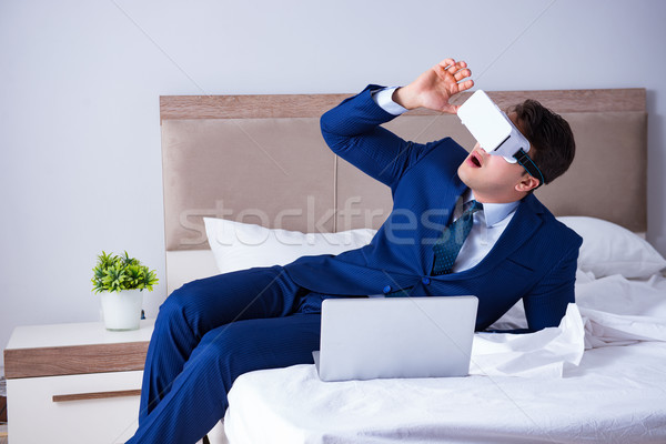 Businessman wearing a virtual reality headset in the bedroom Stock photo © Elnur