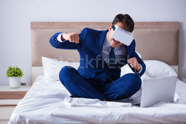 Businessman wearing a virtual reality headset in the bedroom Stock photo © Elnur