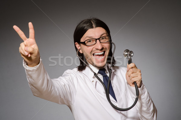 Young physician with stethoscope against gray Stock photo © Elnur