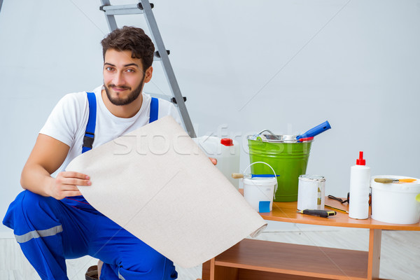 Repairman doing renovation repair in the house with paper wallpa Stock photo © Elnur