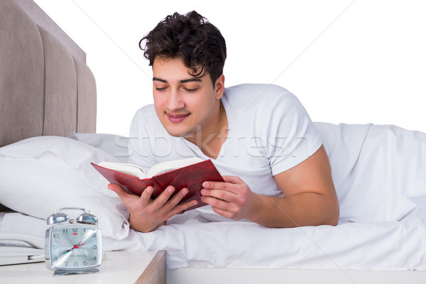 Homme lit souffrance insomnie livre horloge [[stock_photo]] © Elnur