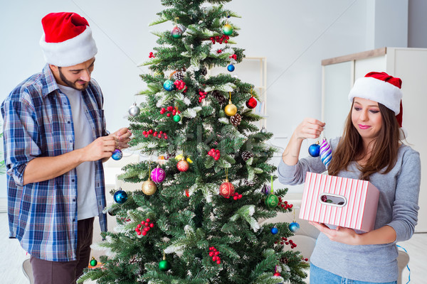 Young family decorating christmas tree on happy occasion Stock photo © Elnur