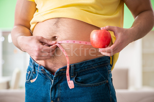 Man measuring body fat with tape measure in dieting concept Stock photo © Elnur