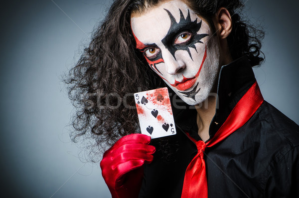 Evil clown with cards in dark room Stock photo © Elnur