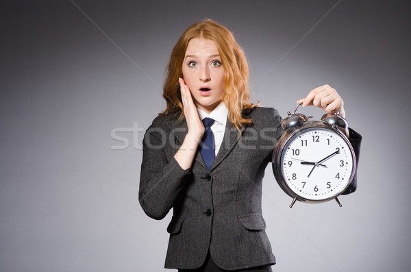 Businesswoman with clock being late for her deliverables Stock photo © Elnur