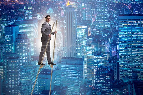 Businessman walking on stilts - standing out from the crowd Stock photo © Elnur