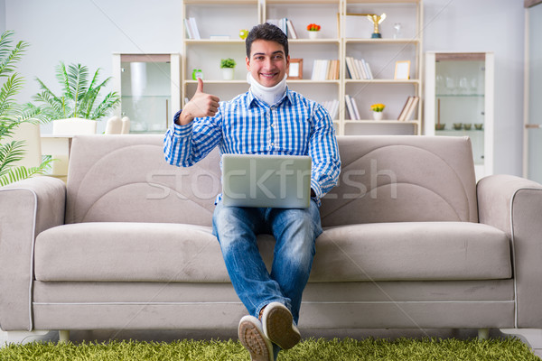 Man freelancer in a cervical collar neck brace working from home Stock photo © Elnur