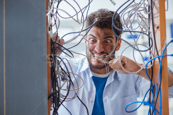 Electrician trying to untangle wires in repair concept Stock photo © Elnur