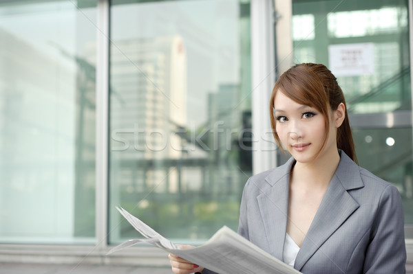 Young business woman reading newspaper Stock photo © elwynn