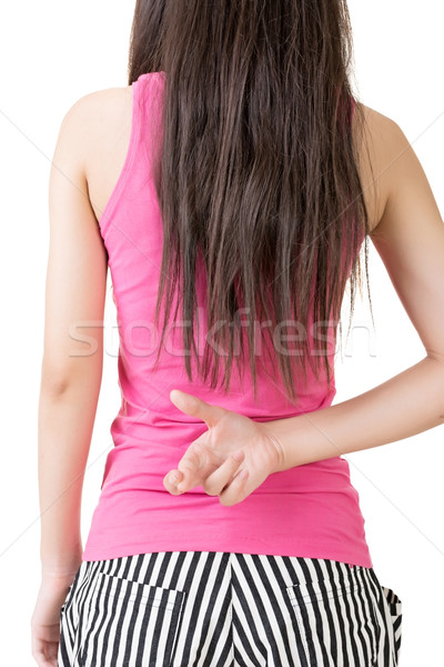 Stock photo: Young asian woman keeps fingers crossed behind her back