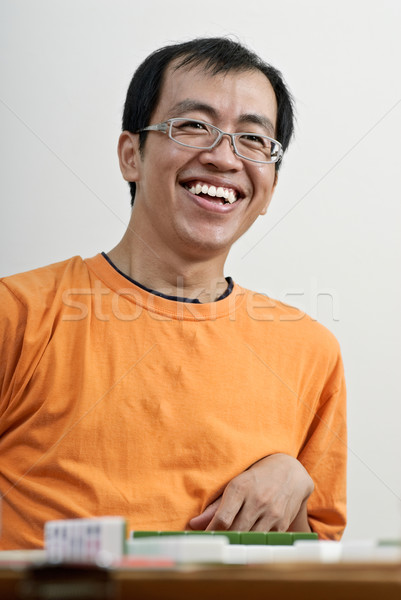 Feliz sorridente asiático homem jogar mahjong Foto stock © elwynn