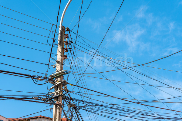 Electric post with a lot of wires Stock photo © elxeneize
