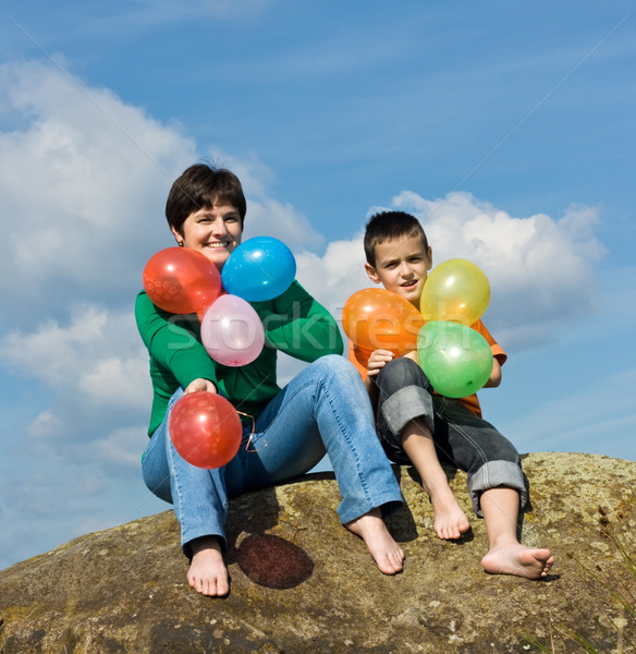 Glückliche Familie Sitzung Stein schöne Frau Sohn Ballons Stock foto © emese73