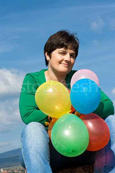 Glücklich Frau Sitzung Stein schöne Frau Ballons Stock foto © emese73