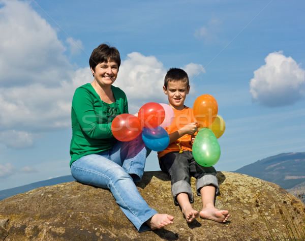 Glückliche Familie Sitzung Stein schöne Frau Sohn Ballons Stock foto © emese73