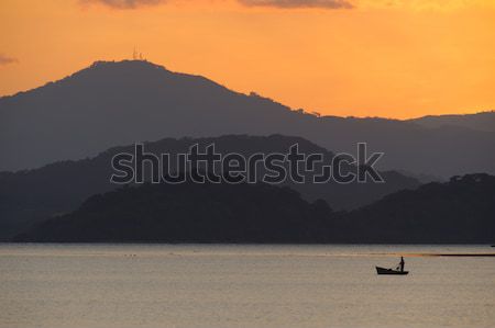 Solitario pescador puesta de sol naranja Foto stock © emiddelkoop