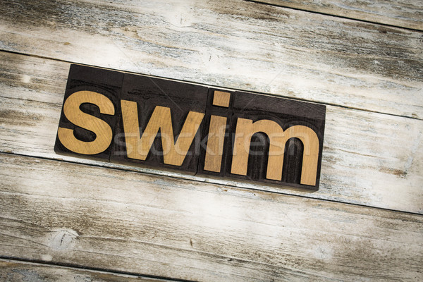 Swim Letterpress Word on Wooden Background Stock photo © enterlinedesign