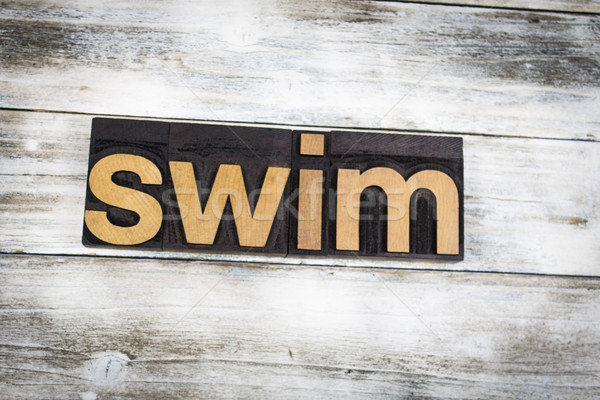 Swim Letterpress Word on Wooden Background Stock photo © enterlinedesign