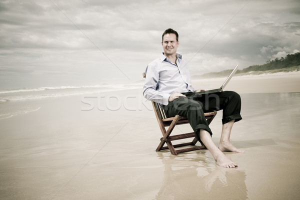 Homem de negócios sessão cadeira praia laptop negócio Foto stock © epstock