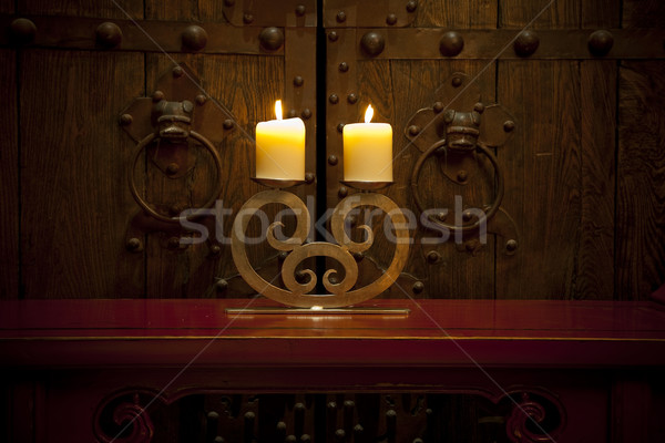 Candles burning on table in front of old rustic door Stock photo © epstock