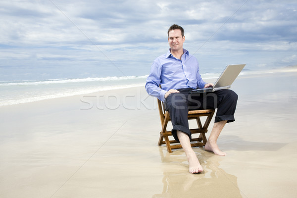 Człowiek biznesu posiedzenia krzesło plaży laptop działalności Zdjęcia stock © epstock