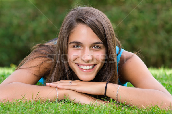 Cute young woman lying on grass in the park Stock photo © ErickN