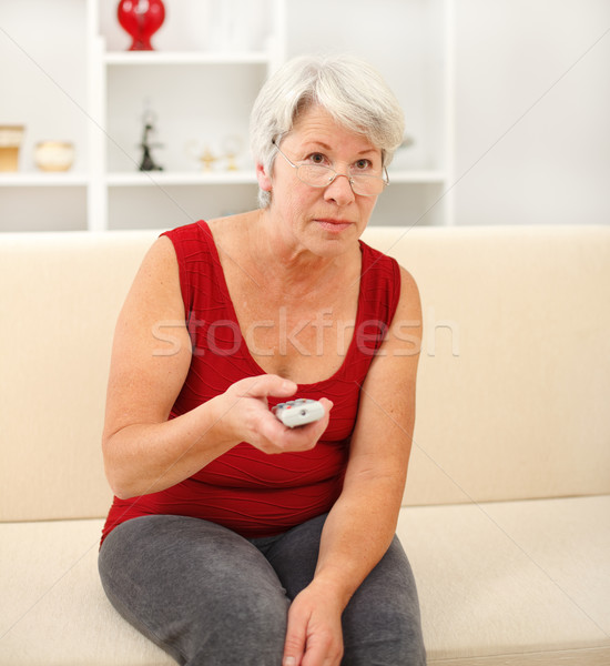 Idős nő néz tv ül kanapé Stock fotó © erierika