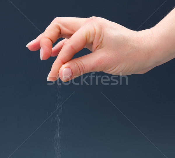 Hand sprinkling salt Stock photo © erierika