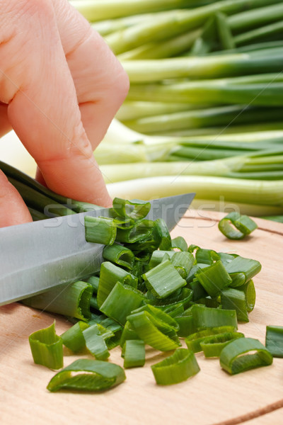 Woman's hand cutting green onion Stock photo © erierika