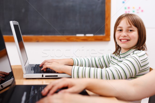 Stock photo: Cheerful schoolgirl with laptop