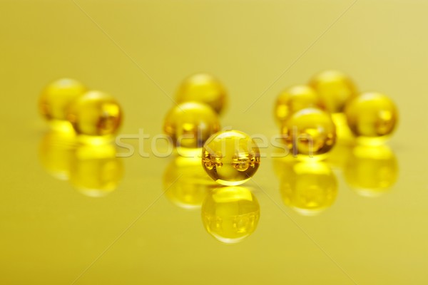 Macro of E vitamine capsules on yellow Stock photo © erierika