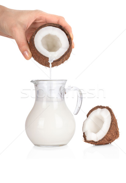 Woman's hand pouring coconut milk into a jar isolated on white b Stock photo © Escander81