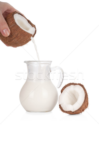 Woman's hand pouring coconut milk into a jar isolated on white Stock photo © Escander81