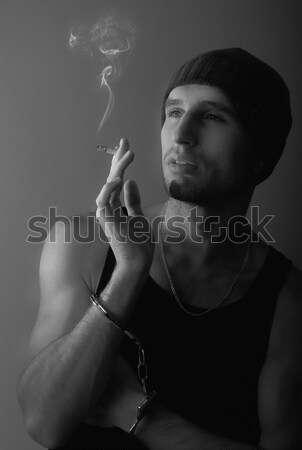 bad man in handcuffs with a cigarette Stock photo © evgenyatamanenko