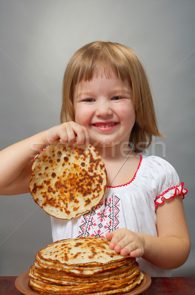 Stock photo: little girl eats pancakes