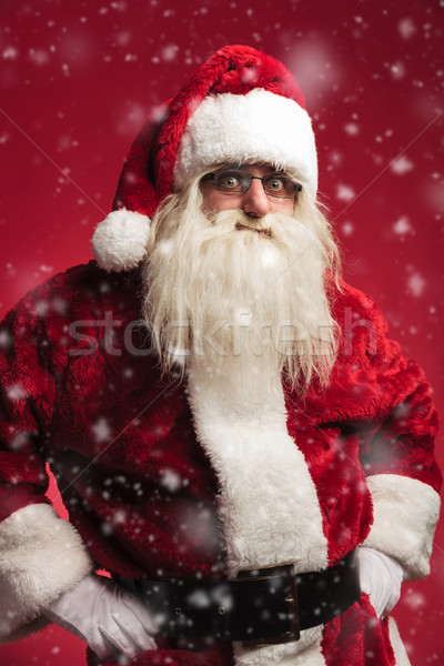 amazed santa claus standing with hands on waist while snowing Stock photo © feedough