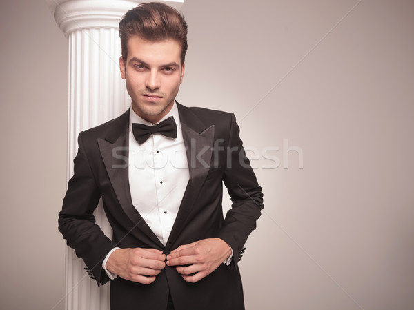 Stock photo: young elegant business man closing his jacket.