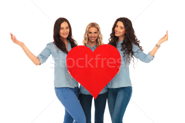 three smiling casual women welcoming to their heart Stock photo © feedough