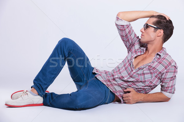 casual man on floor, holds hand in his hair Stock photo © feedough