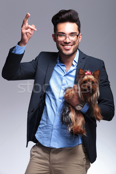 casual young man holds puppy and shoots with hand Stock photo © feedough