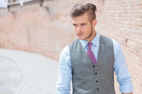 casual man walks by a brick wall Stock photo © feedough