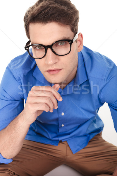 handsome young fashion man sitting on isolated background Stock photo © feedough