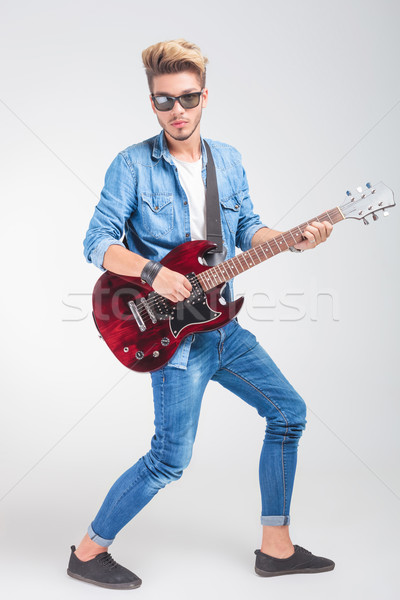 artist playing guitar in studio background while posing Stock photo © feedough