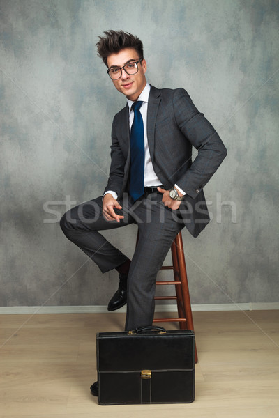 happy young business man sitting near brief case  Stock photo © feedough